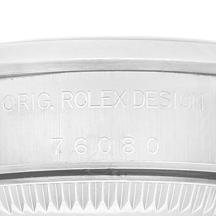 This is a close-up angle showing the engraved model information on the casing of a Rolex Oyster Perpetual 76080 Women's Stainless Steel Blue Dial 76080 Women's Stainless Steel Blue Dial watch.