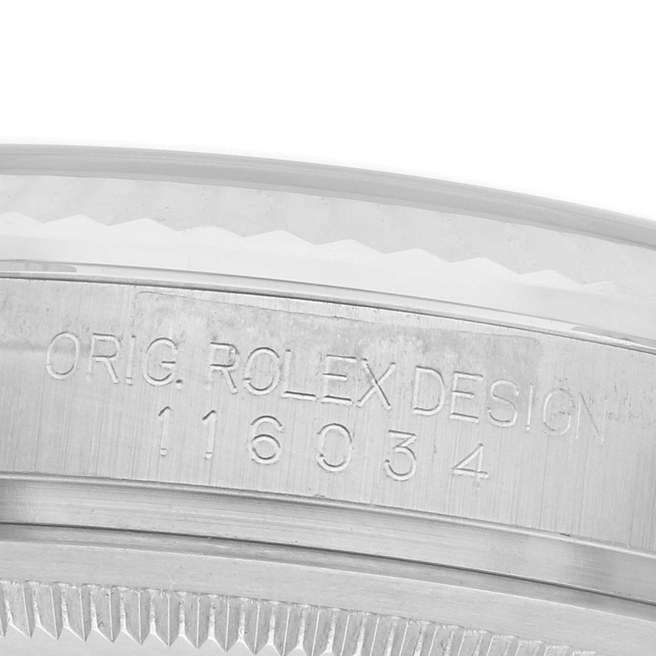 The image shows a close-up of the engraved bezel area of a Rolex Oyster Perpetual 116034 Men
s Stainless Steel Silver Dial watch.