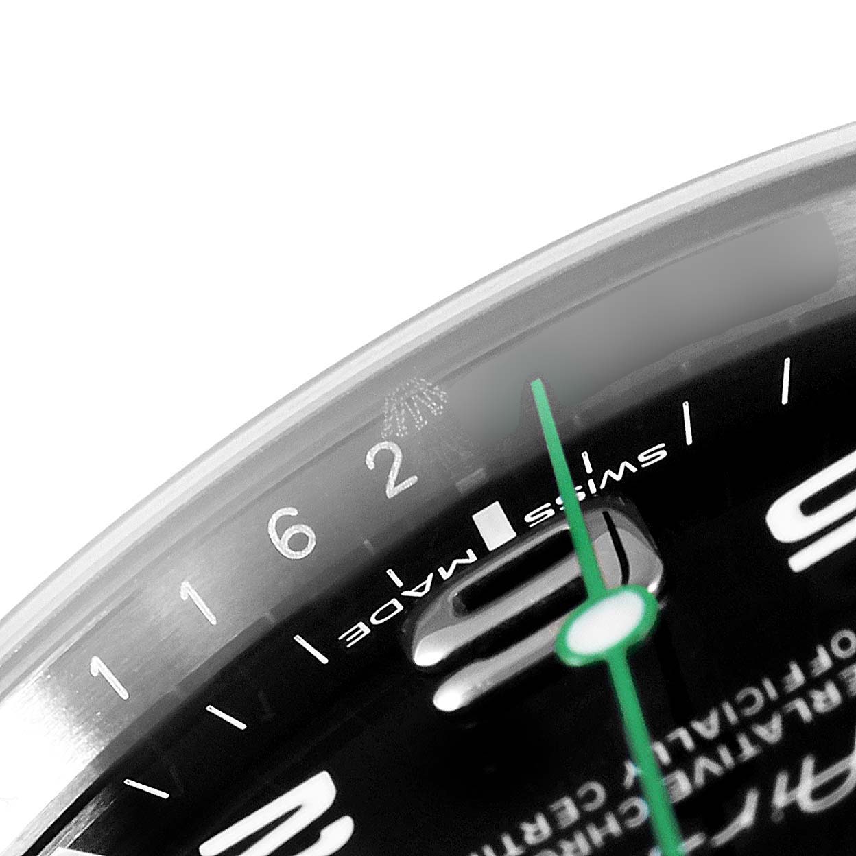 A close-up of the Rolex Air-King 116900 Men's Stainless Steel Black Dial 116900 Men's Stainless Steel Black Dial watch showing the 12 o'clock area, including the numerals, green second hand, and part of the Rolex crown logo.