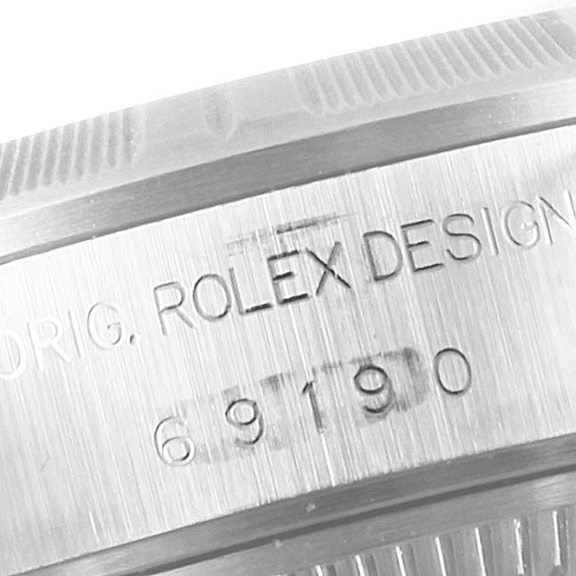 The close-up image displays the engraved serial number and "ROLEX DESIGN" text on the side bezel of a Rolex Date 69190 Women's Stainless Steel Pink Dial 69190 Women's Stainless Steel Pink Dial model watch.
