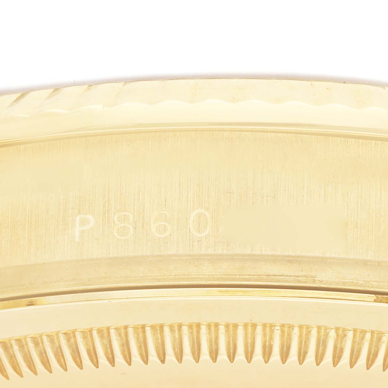 The image shows the side view of a Rolex President 118238 Men
s Yellow Gold Champagne Dial watch, highlighting the engraved serial number and part of the fluted bezel.