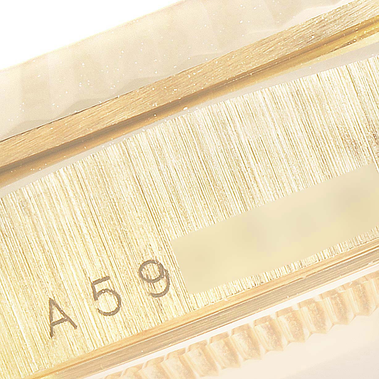 This image shows a close-up of the serial number engraving on the side of a Rolex President 18238 Men's Yellow Gold Champagne Dial 18238 Men's Yellow Gold Champagne Dial model watch.