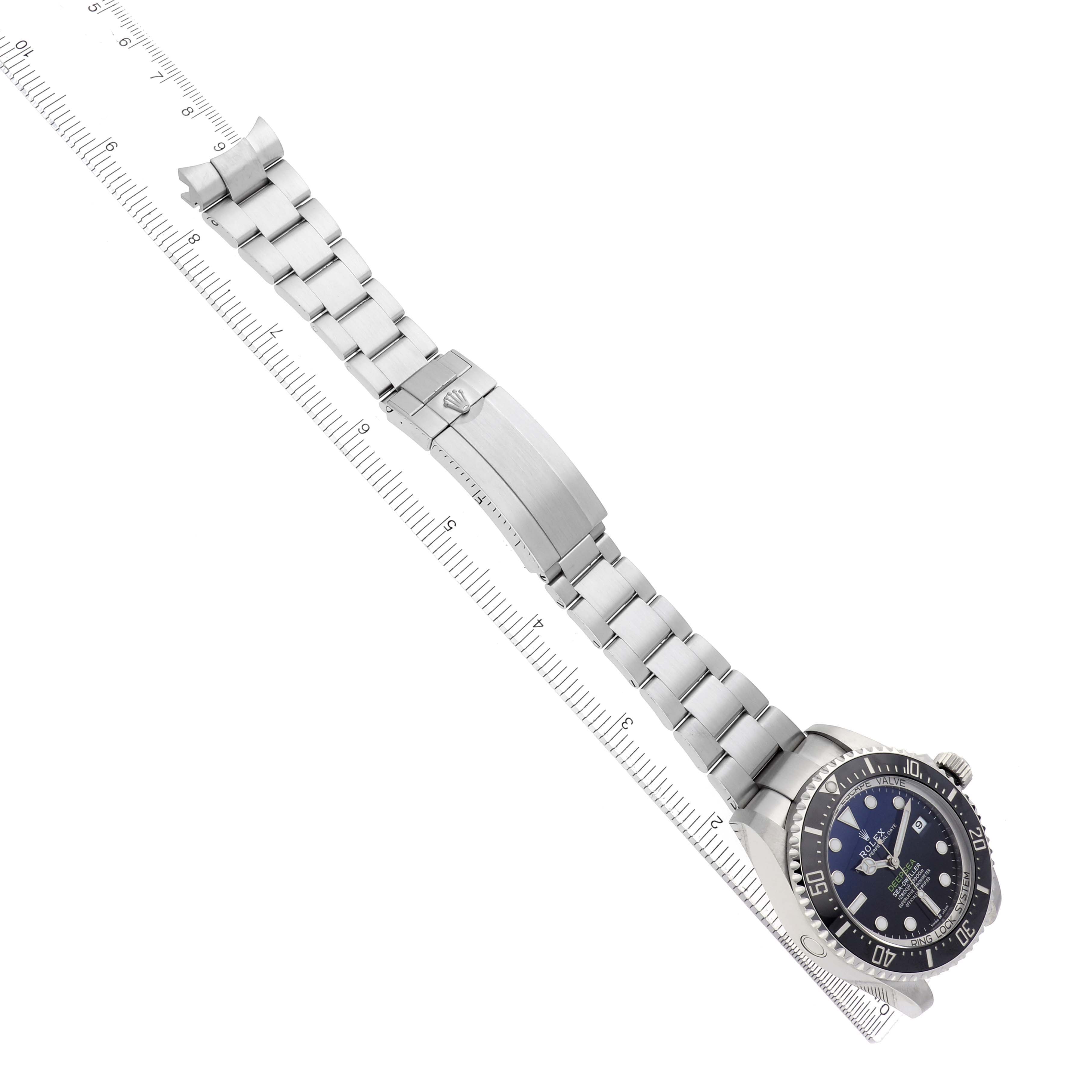 The Rolex Sea-Dweller 73113 Men
s Stainless Steel Blue Dial watch is shown at an overhead angle, displaying the full bracelet and face next to a ruler.