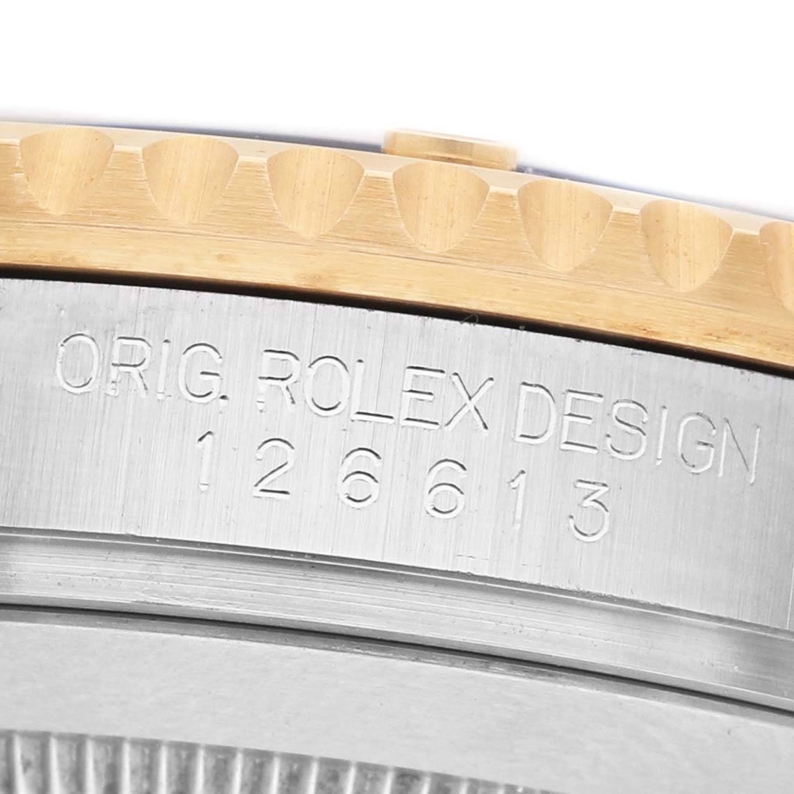 The image shows a close-up of the side, displaying the engraving and edge of the bezel of a Rolex Submariner 126613LB Men's Steel and Gold (two tone) Blue Dial.