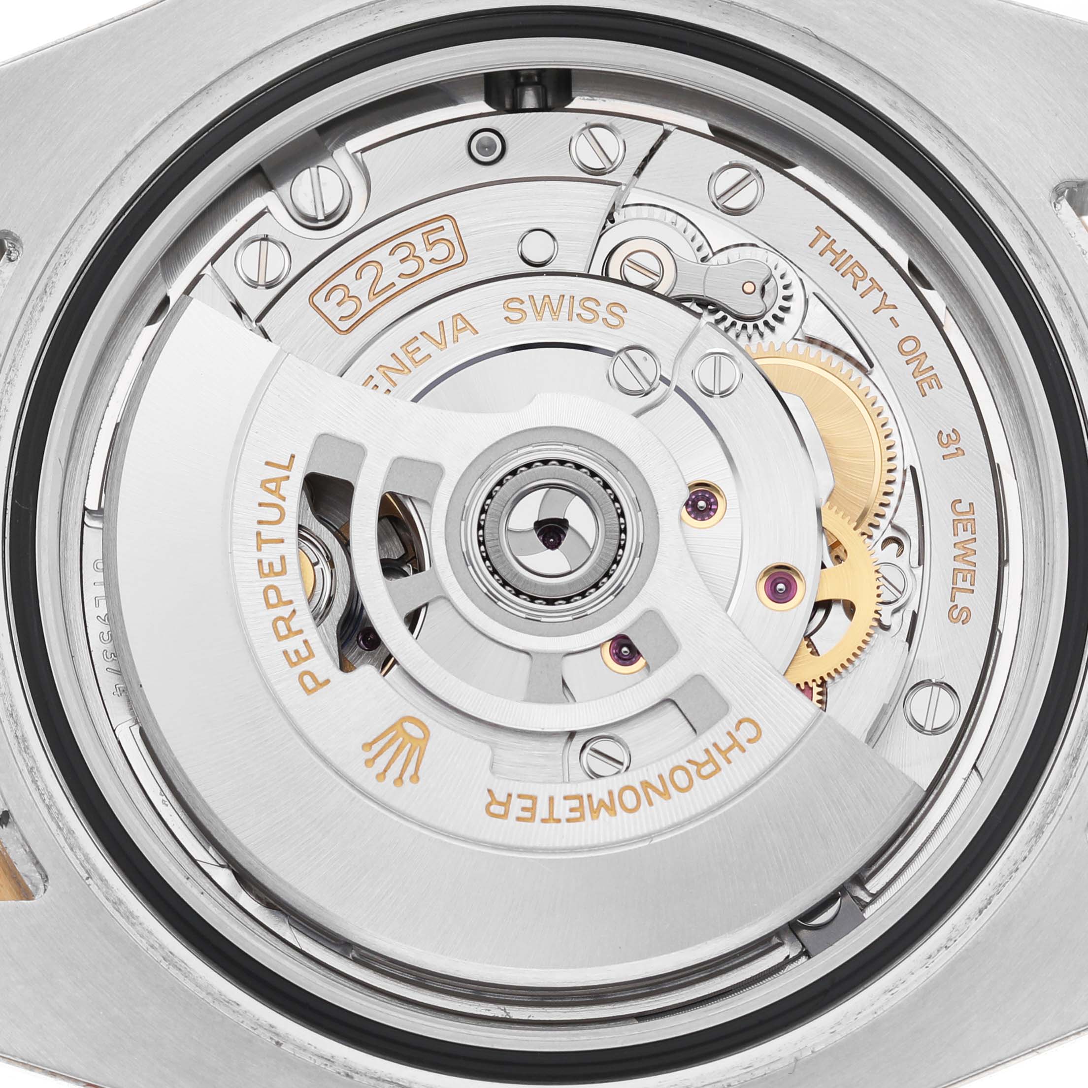 The image shows a close-up view of the movement inside a Rolex Submariner 126613LB Men's Steel and Gold (two tone) Blue Dial, highlighting the 3235 caliber and intricate mechanical parts.
