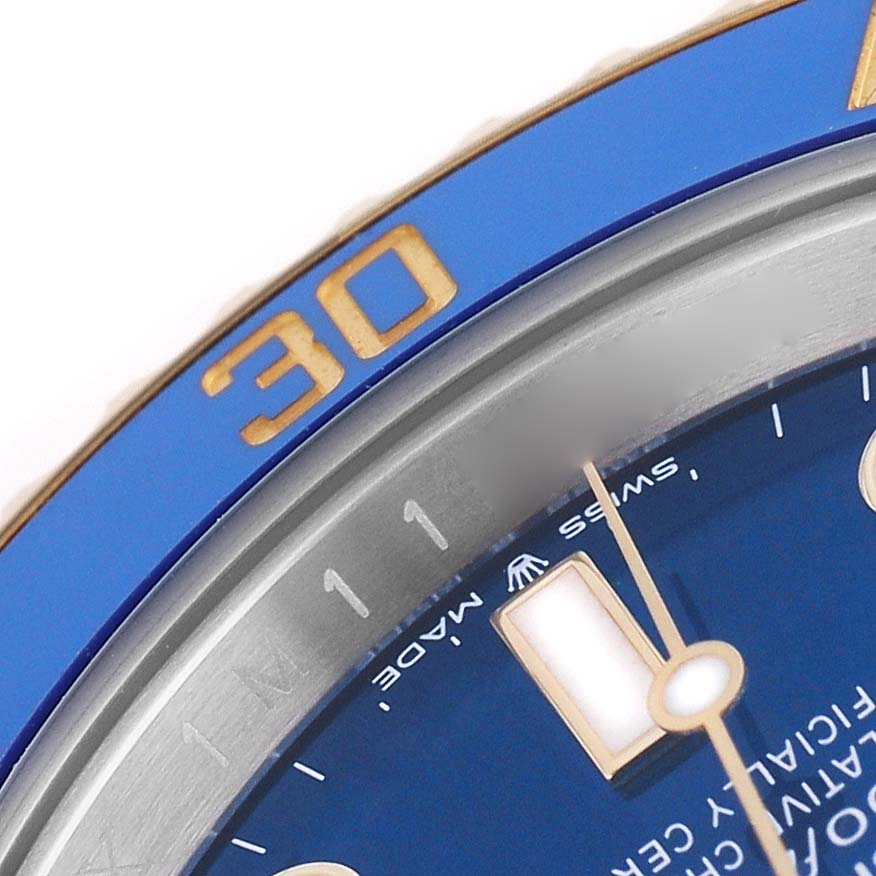 The image shows a close-up of the Rolex Submariner 126613LB Men's Steel and Gold (two tone) Blue Dial bezel and a portion of the dial, highlighting the blue and gold color scheme.