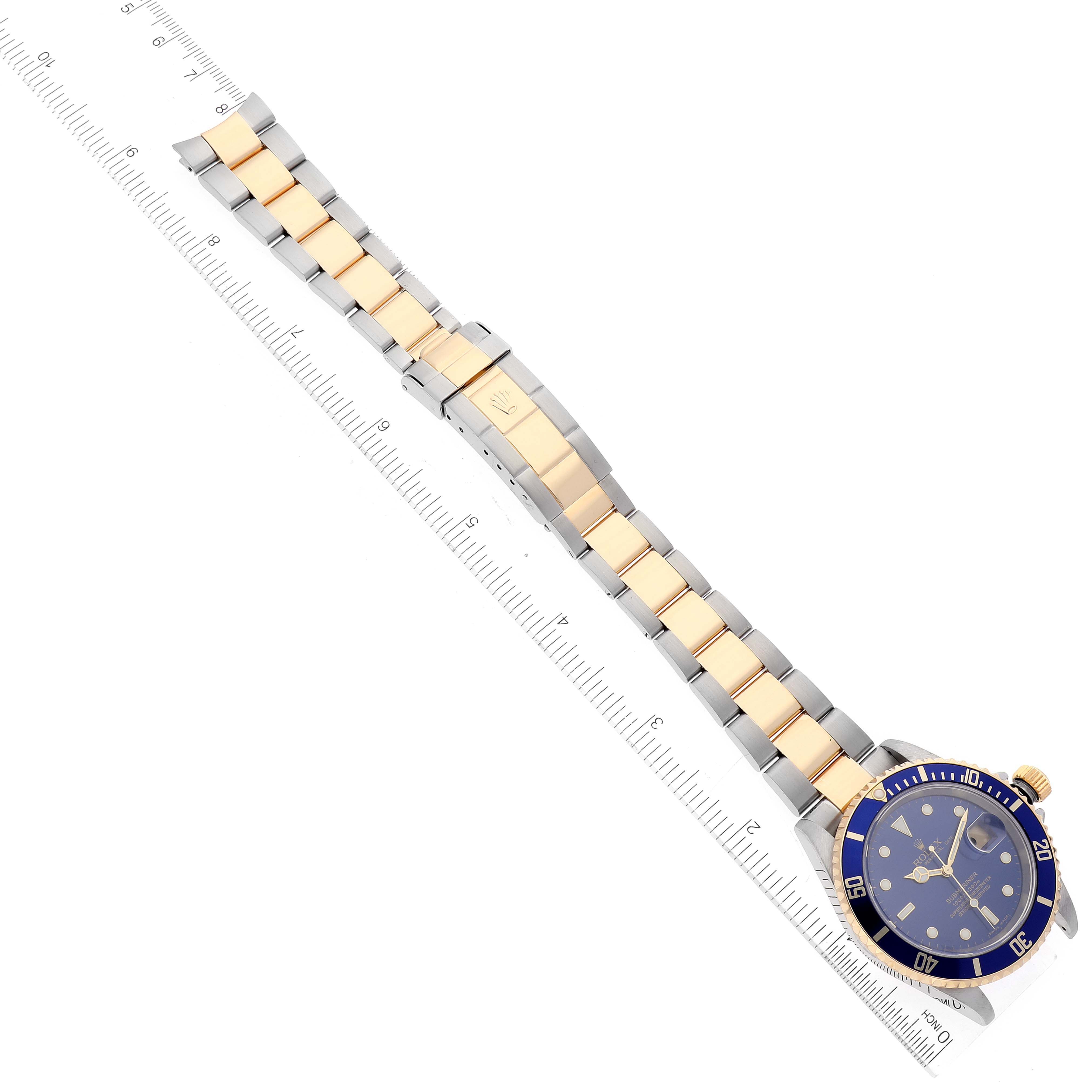 The image shows a top-down view of the Rolex Submariner 16613 Men's Steel and Gold (two tone) Blue Dial 16613 Men's Steel and Gold (two tone) Blue Dial watch, displaying the face, bezel, and full bracelet with a measurement scale.