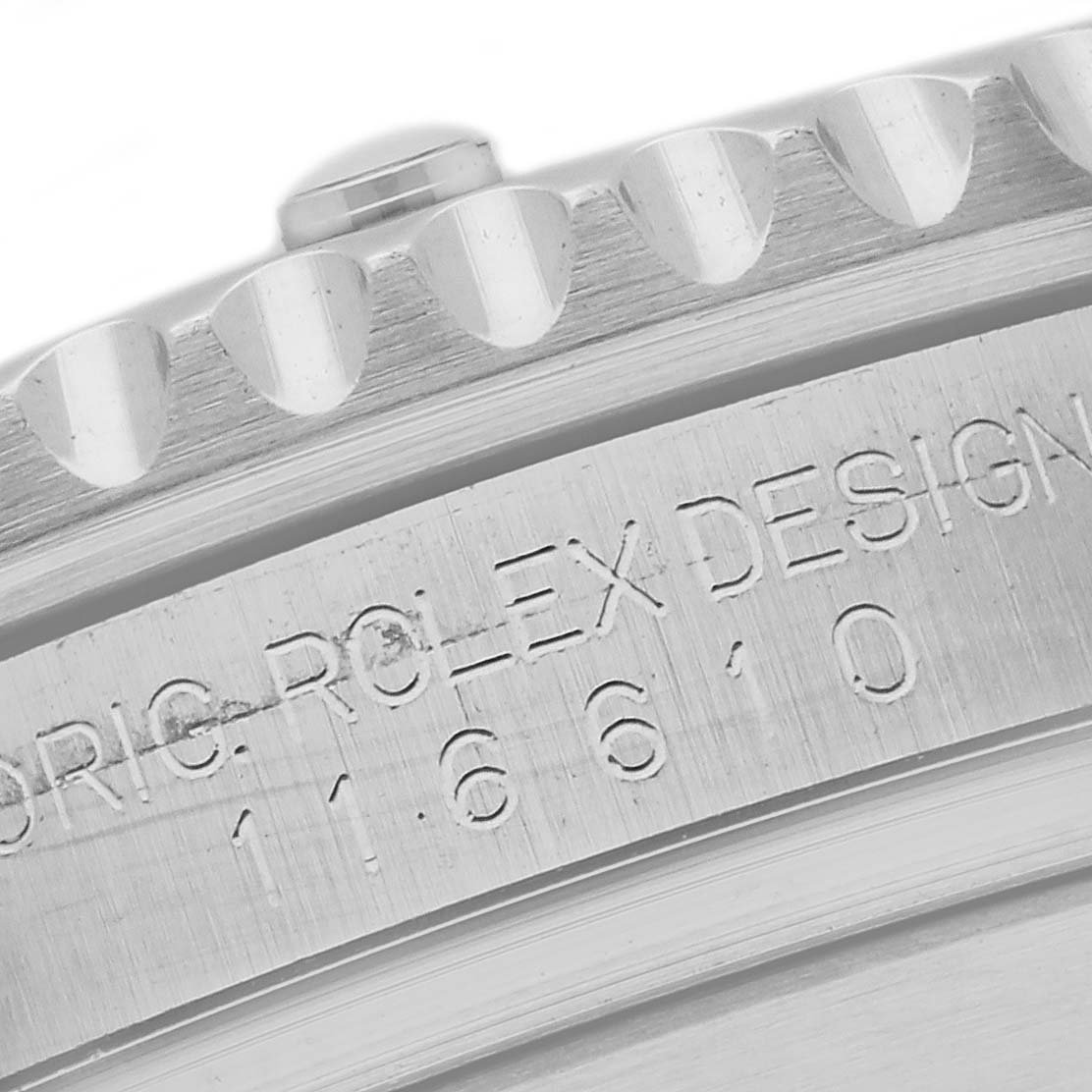 Close-up of the side of a Rolex Submariner 116610LV Men's Stainless Steel Green Dial 116610LV Men's Stainless Steel Green Dial, showing the edge of the bezel and engraved model information.