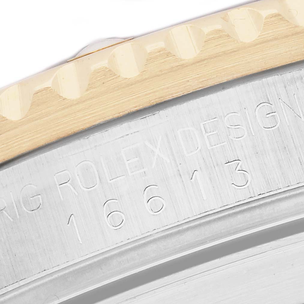 The image shows a close-up of the engraved side of the bezel and case of a Rolex Submariner 16613 Men
s Steel and Gold (two tone) Champagne Dial watch, model 16613.