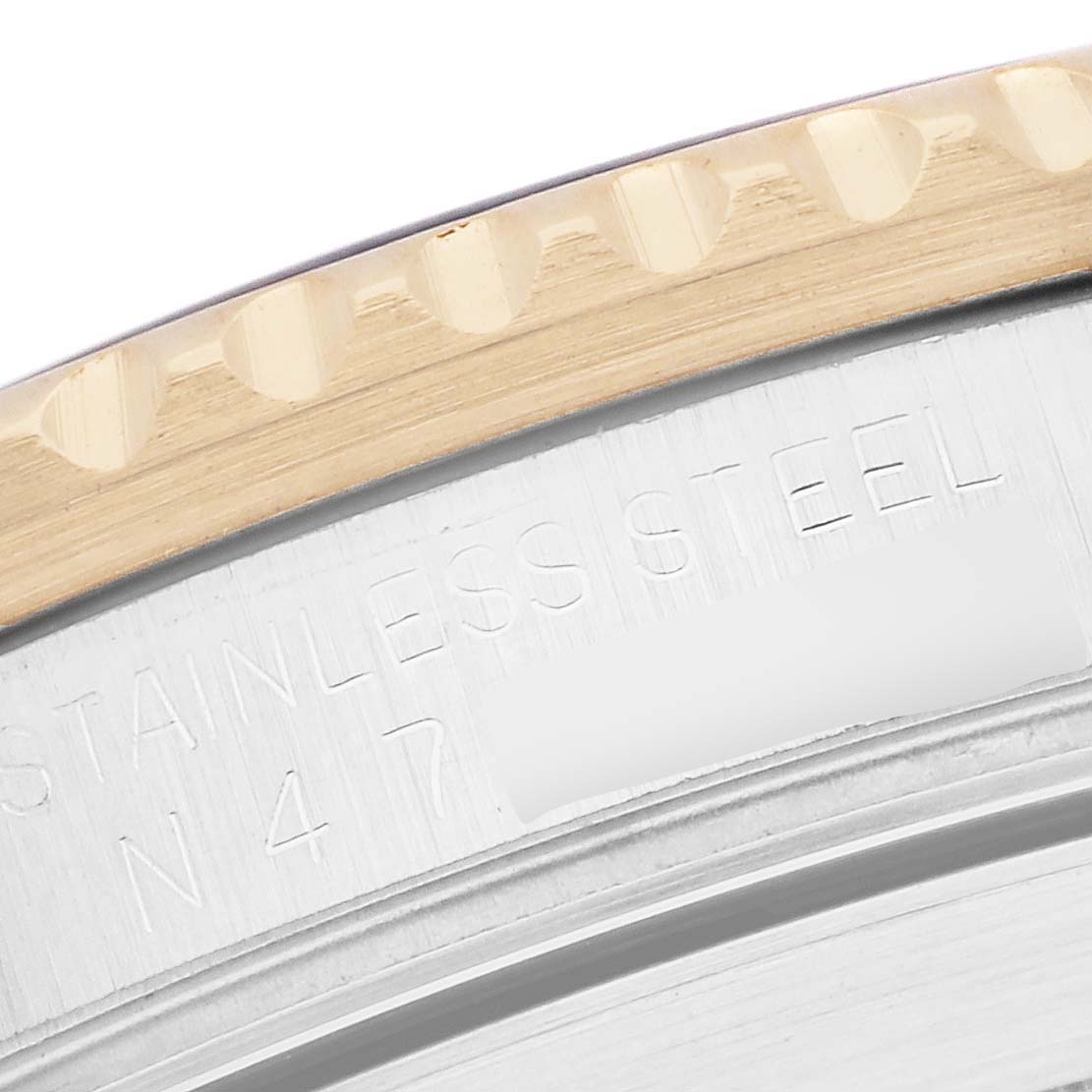 The image shows a close-up of the bezel and case edge of a Rolex Submariner 16613 Men
s Steel and Gold (two tone) Champagne Dial, highlighting the stainless steel and notched design.
