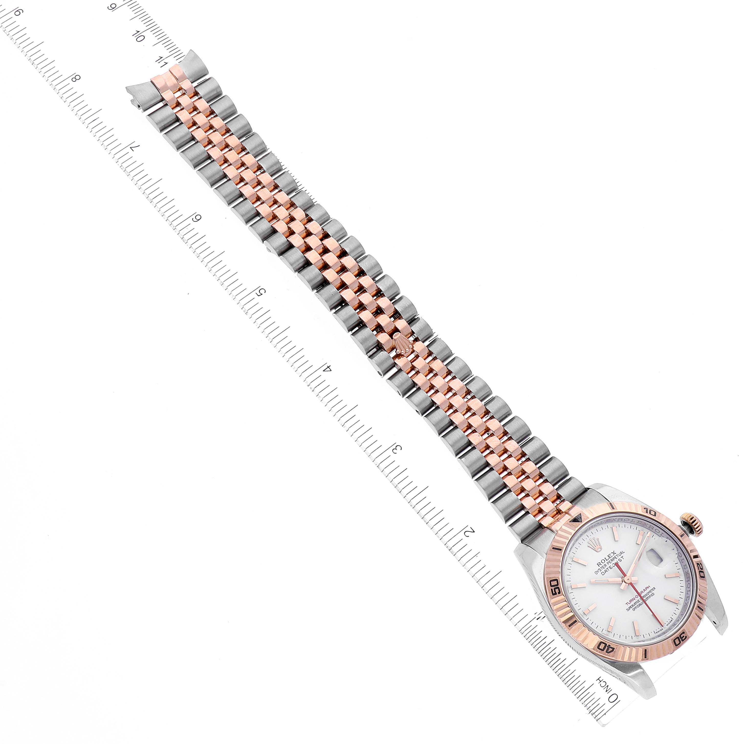 The image shows the Rolex Turn-o-Graph 116261 Men's Steel and Gold (two tone) White Dial 116261 Men's Steel and Gold (two tone) White Dial watch from a top-down angle, highlighting its face and two-tone bracelet laid along a ruler.