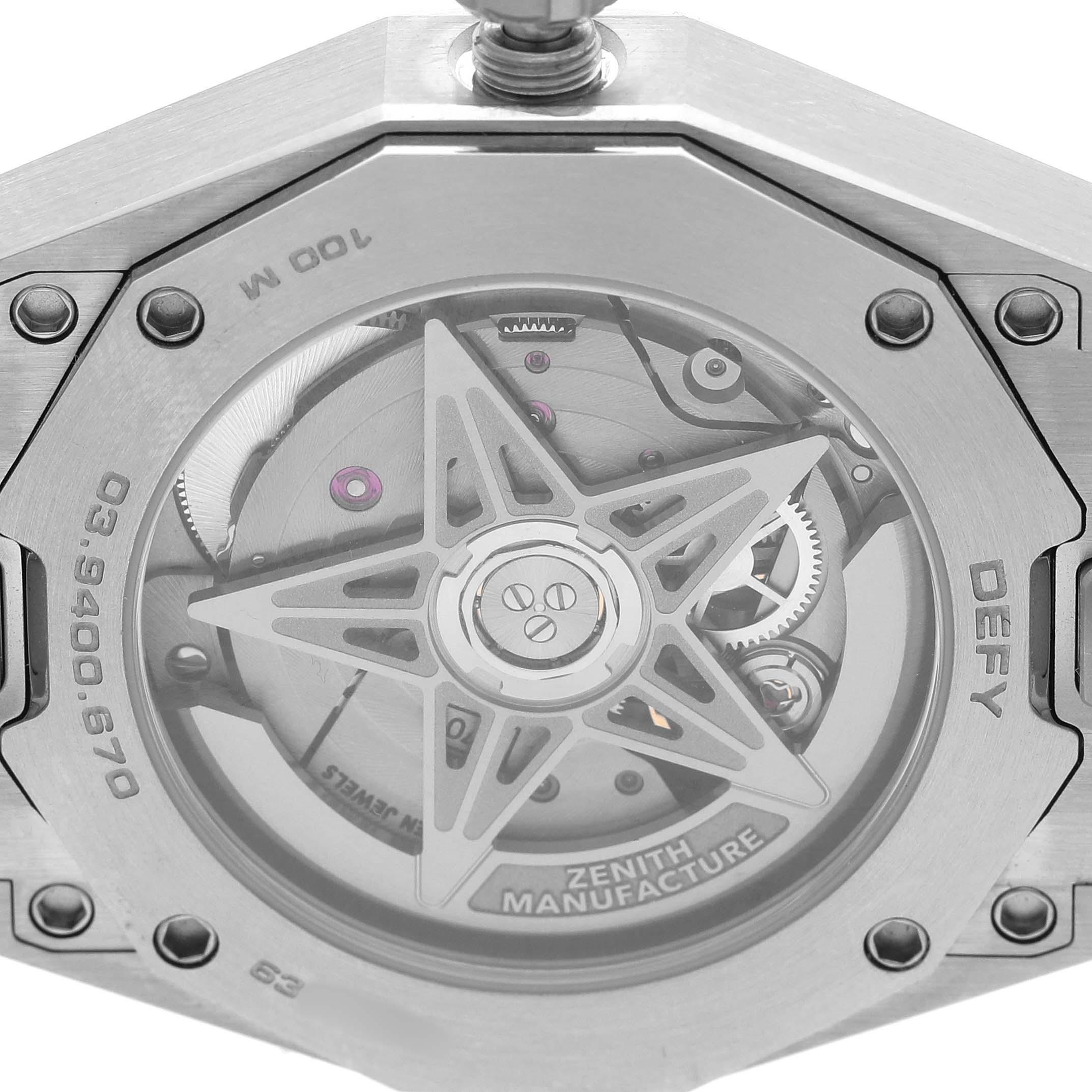 The image shows the back of a Zenith Defy 03.9400.670/61.I001 Men's Stainless Steel Green Dial watch, highlighting the movement and rotor with visible screws.