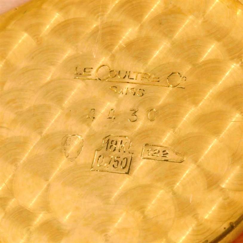 The image shows the interior back casing of a Vintage Jaeger LeCoultre watch, engraved with markings and the "18K 0.750" gold purity stamp.