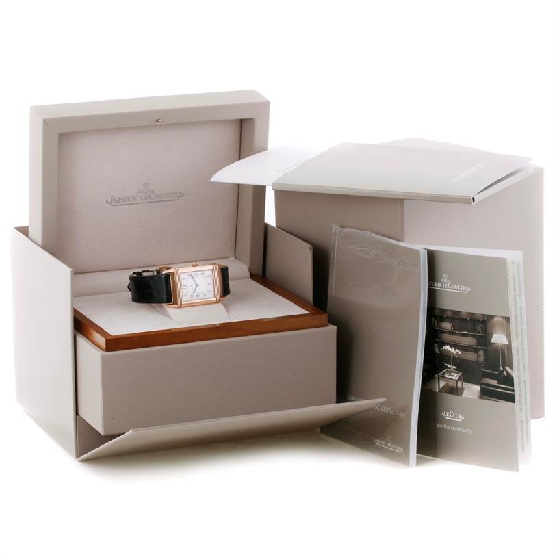 The image shows a Jaeger LeCoultre Reverso Q2782520 Men's Rose Gold Silver Dial Q2782520 Men's Rose Gold Silver Dial watch inside an open box, with manuals and accessories beside it.