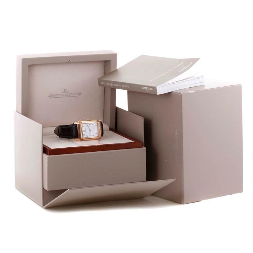 The Jaeger LeCoultre Reverso Q3742421 Men's Rose Gold Silver Dial Q3742421 Men's Rose Gold Silver Dial watch is shown inside an open box, accompanied by its booklet and packaging.