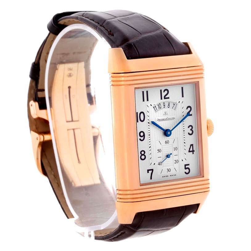 The image shows a Jaeger-LeCoultre Reverso watch from a three-quarter angle, highlighting its rectangular casing, dial, and leather strap.