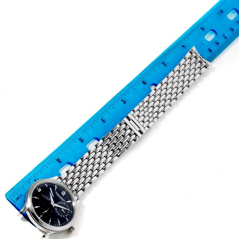 This image shows a Jaeger LeCoultre Master 140.8.93.S Men's Stainless Steel Black Dial 140.8.93.S Men's Stainless Steel Black Dial model watch laid flat with a metal bracelet beside a blue ruler.