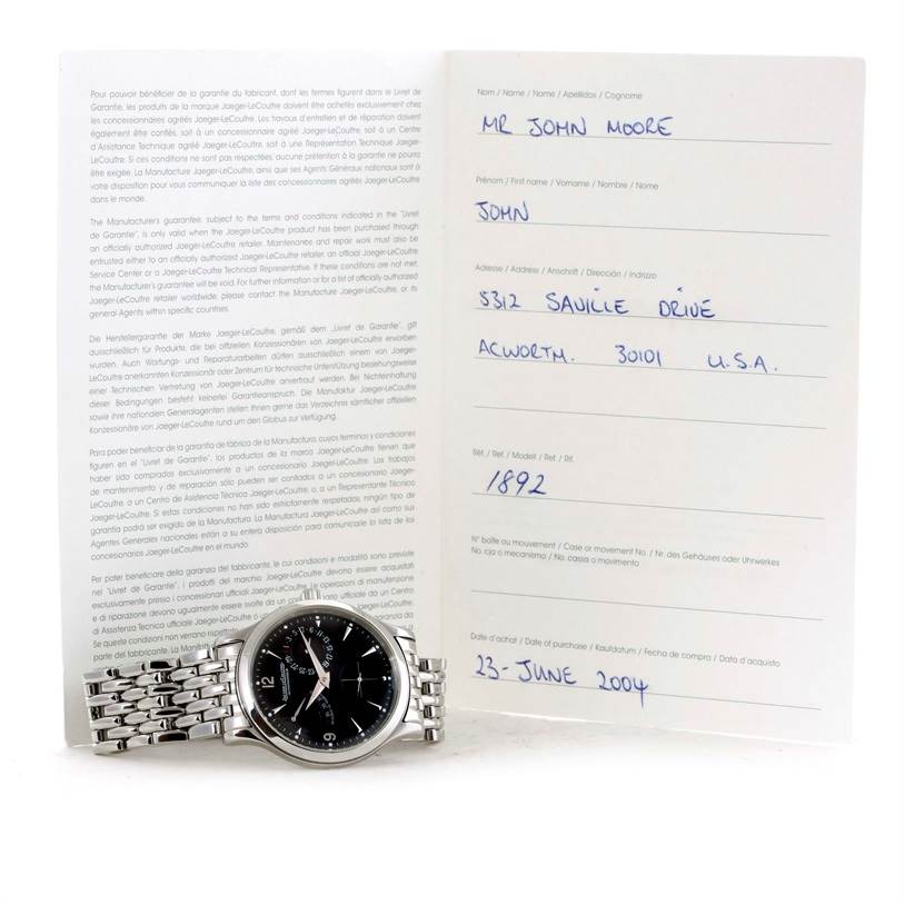 The image shows a Jaeger LeCoultre Master 140.8.93.S Men's Stainless Steel Black Dial 140.8.93.S Men's Stainless Steel Black Dial model watch placed in front of documentation, displaying its face and metal bracelet.