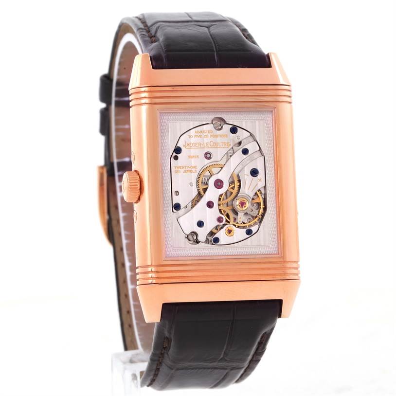 The image shows a side-angle view of the Jaeger LeCoultre Reverso Q3752520 Men's Rose Gold Silver Dial Q3752520 Men's Rose Gold Silver Dial watch, highlighting its intricate inner mechanics and leather strap.