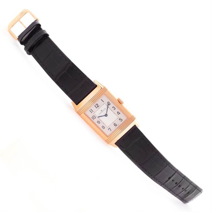 The image shows a Jaeger LeCoultre Reverso Q2782520 Men's Rose Gold Silver Dial Q2782520 Men's Rose Gold Silver Dial watch from a top-down angle featuring its face, leather strap, and buckle.