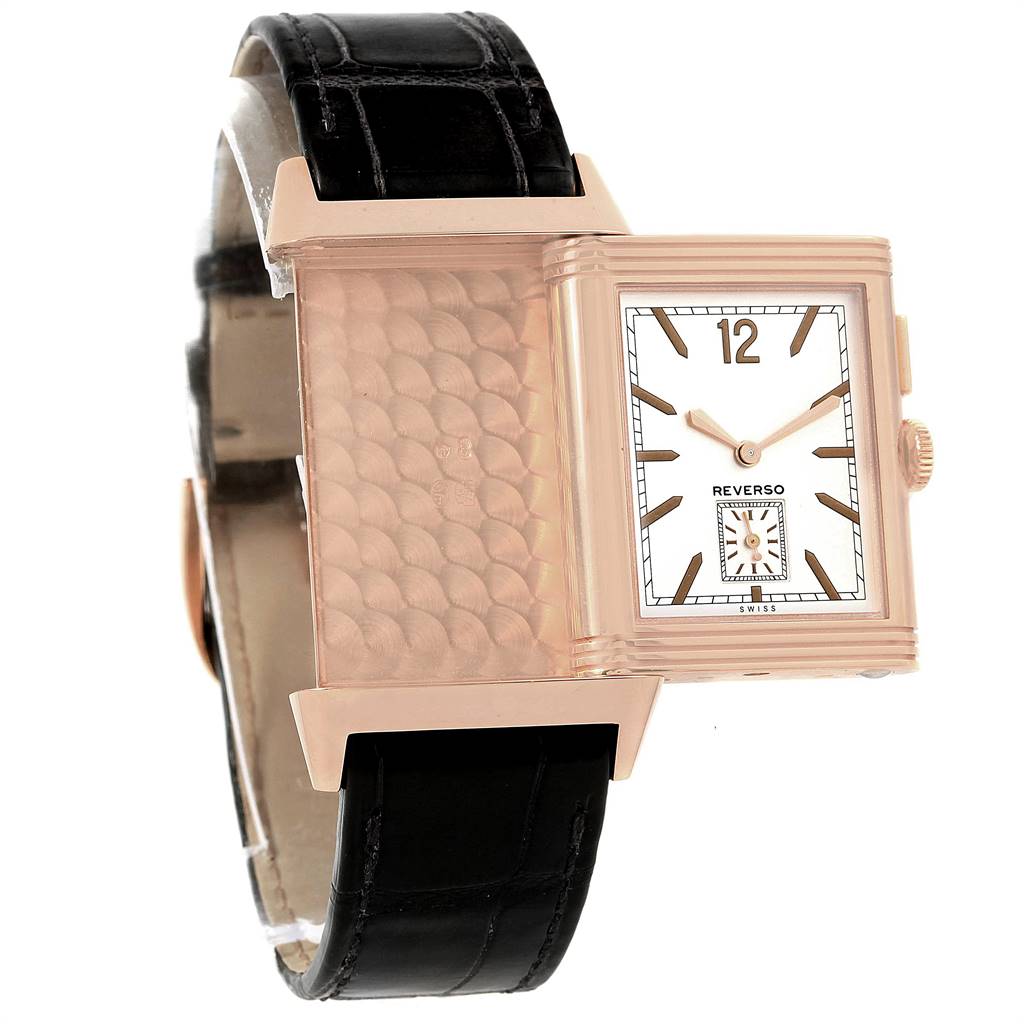 The Reverso watch by Jaeger LeCoultre is shown in a side angle, showcasing its reversible case and black leather strap.