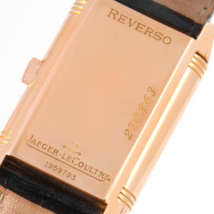 The image shows the back of a Jaeger-LeCoultre Reverso watch, displaying engraving details and the crown on the side.