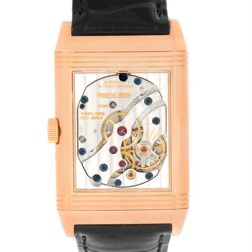 The image shows the rear view of a Jaeger-LeCoultre Reverso watch with visible mechanical components.