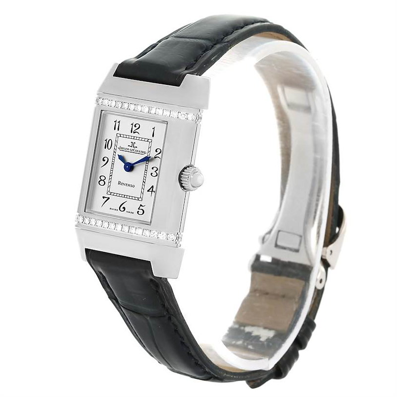 The Jaeger-LeCoultre Reverso watch is shown at an angled view, highlighting the rectangular dial, crown, and black leather strap.