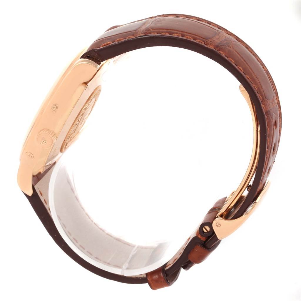 This image shows a side view of a Jaeger LeCoultre Master 140.2.87 Men's Rose Gold Silver Dial 140.2.87 Men's Rose Gold Silver Dial watch, highlighting its gold case and brown leather strap.