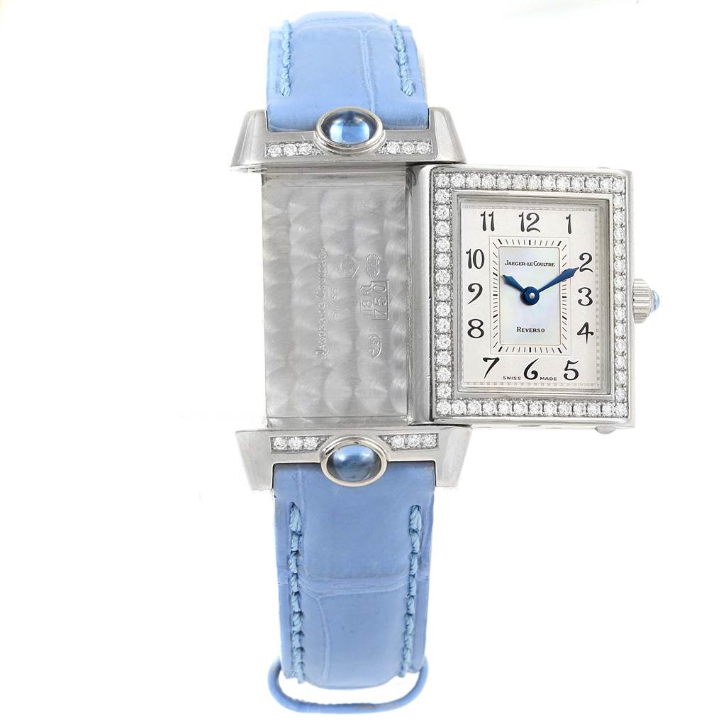 The image shows the front and back of a Jaeger LeCoultre Reverso Q2623402 Women's White Gold Mother of Pearl Dial Q2623402 Women's White Gold Mother of Pearl Dial watch with a rectangular face and a blue strap.
