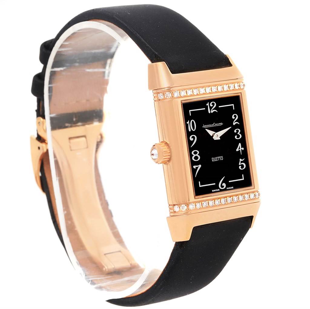 This Jaeger LeCoultre Reverso Q2562402 Women
s Rose Gold Silver Dial Q2562402 Women
s Rose Gold Silver Dial watch is shown at a slight side angle, highlighting its black dial, rose gold case, and black strap.