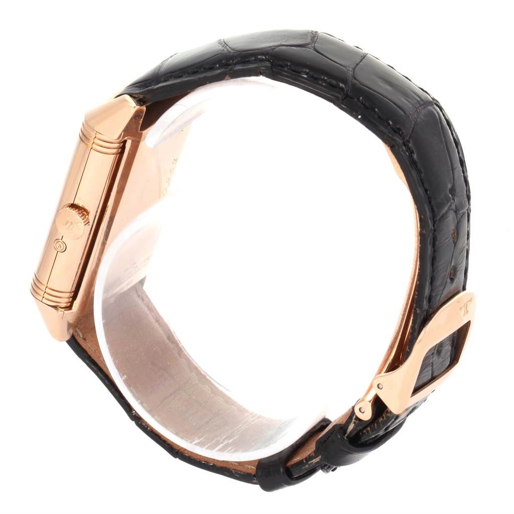 The image shows the side view of a Jaeger LeCoultre Reverso Q3042420 Men's Rose Gold Silver Dial Q3042420 Men's Rose Gold Silver Dial watch, highlighting its gold case, crown, and black leather strap.
