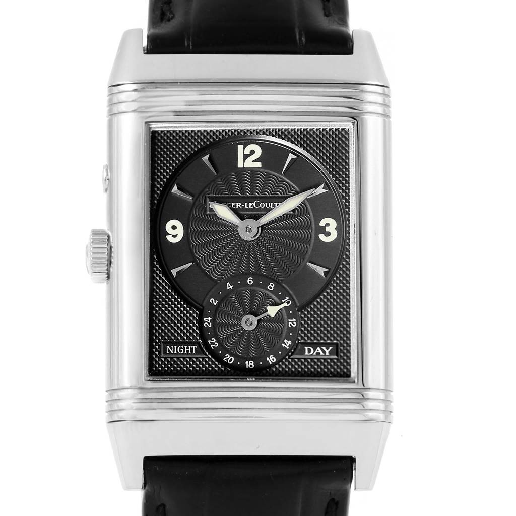 The Jaeger-LeCoultre Reverso watch is shown from the front, displaying its black dial, numerals, day-night indicator, and crown.
