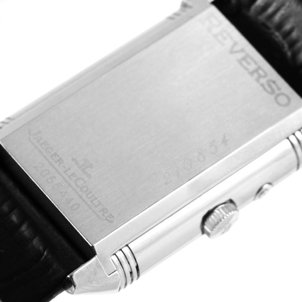 The image shows the back of a Jaeger-LeCoultre Reverso watch, focusing on its rectangular case and crown.