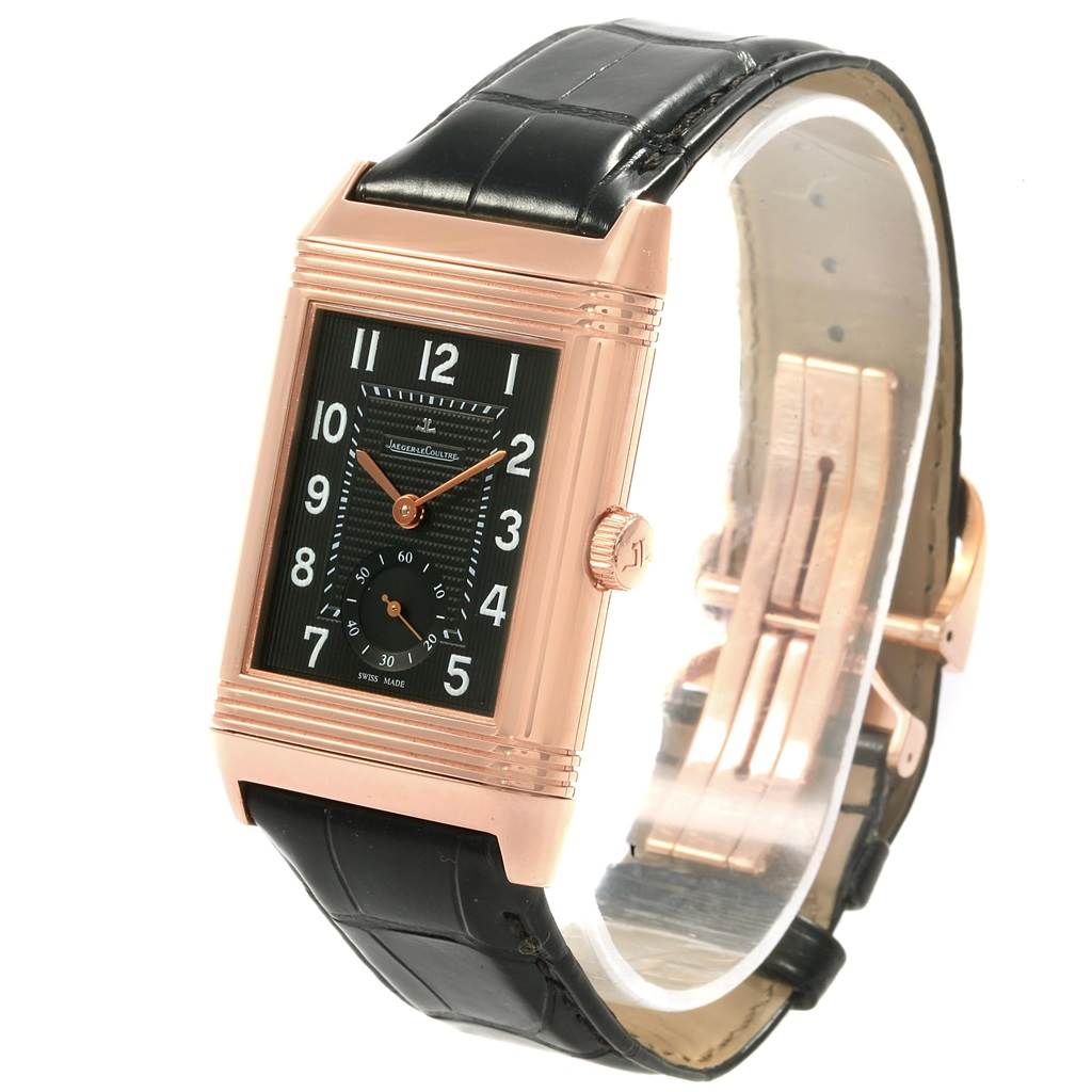 The Jaeger-LeCoultre Reverso watch is shown at an angle displaying its front, strap, crown, and clasp.