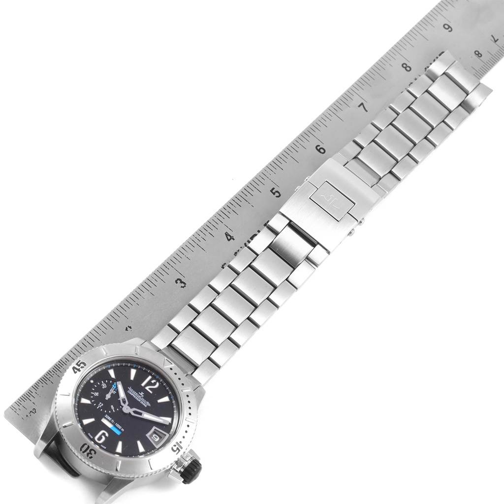 The image shows a Jaeger LeCoultre Master 160.T.05 Men's Titanium Black Dial 160.T.05 Men's Titanium Black Dial model watch laid flat on a ruler, displaying the face and metal bracelet.