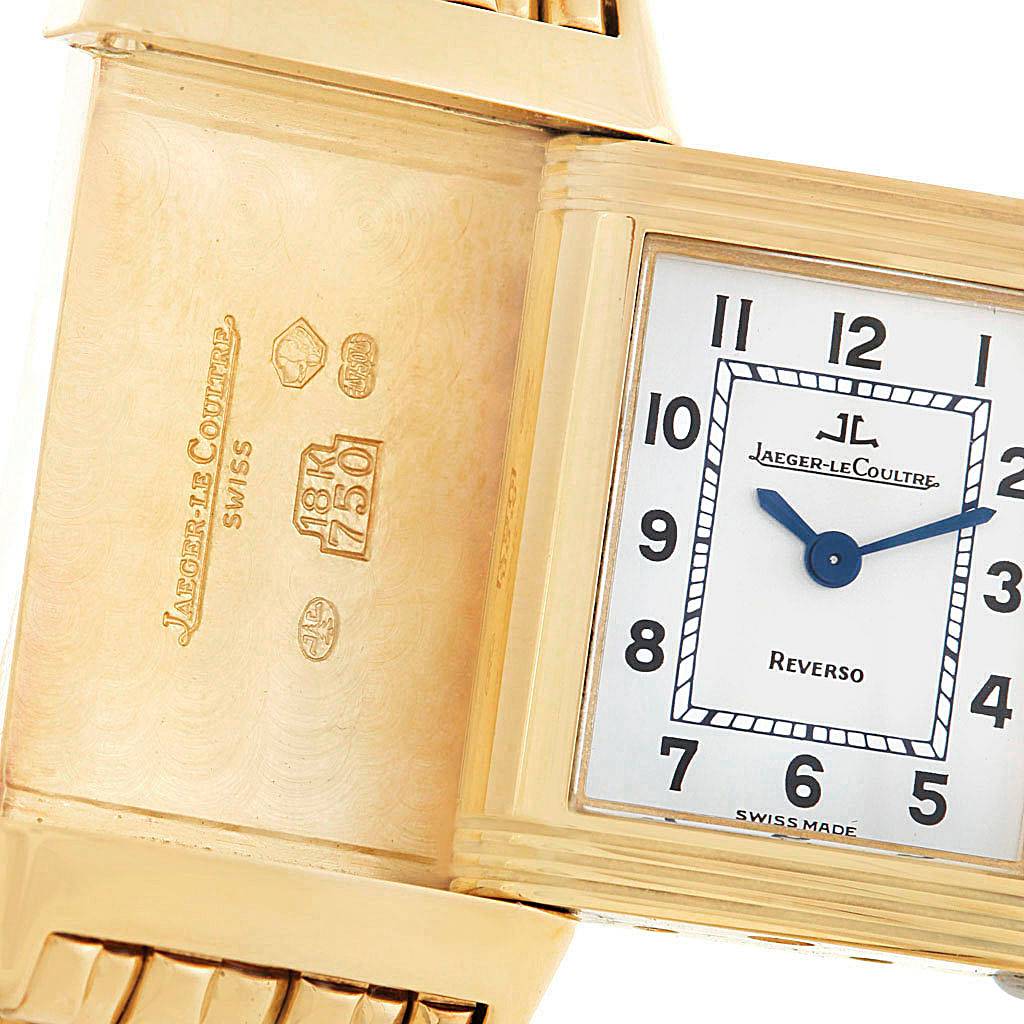 The image shows a Jaeger-LeCoultre Reverso watch with its case swiveled open, revealing its engravings and dial.