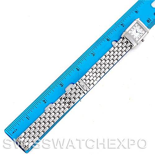 The image shows a Jaeger-LeCoultre Reverso watch laid flat with its face and metal bracelet band alongside a ruler for scale.