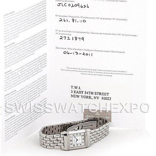 The image shows a Jaeger-LeCoultre Reverso watch with a metal bracelet, placed in front of its documentation.
