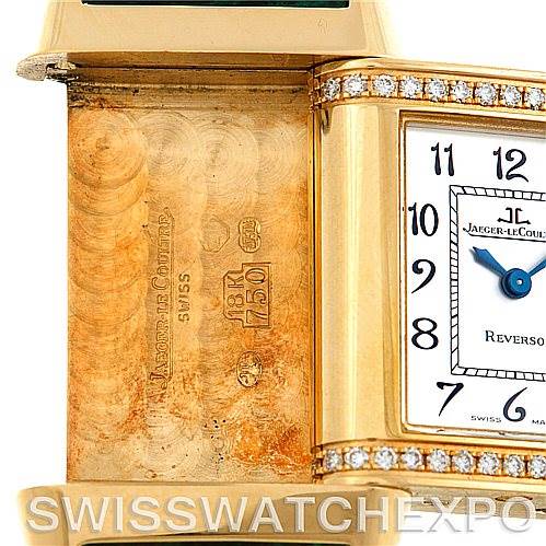 The image shows a close-up of a Jaeger LeCoultre Reverso 265108 Women's Yellow Gold Silver Dial 265108 Women's Yellow Gold Silver Dial watch, highlighting its 18K gold case, Swiss markings, and diamond accents.