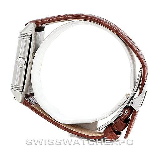 The Jaeger-LeCoultre Reverso watch is shown from a side angle, highlighting the watch case, crown, and brown leather strap.