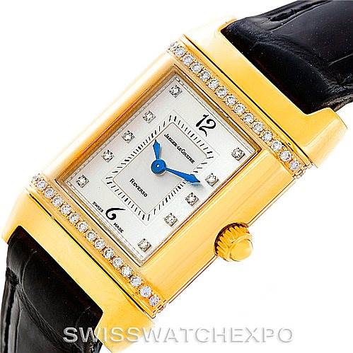 The Jaeger LeCoultre Reverso 265.1.08 Women's Yellow Gold Mother of Pearl Dial 265.1.08 Women's Yellow Gold Mother of Pearl Dial watch is shown from an angled top view, highlighting its rectangular face, diamond bezel, crown, and leather strap.
