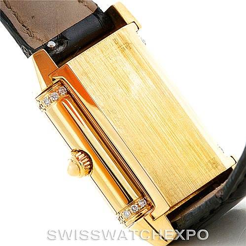 The image shows a side view of a Jaeger-LeCoultre Reverso watch with its gold case and crown, partially displaying its leather strap.