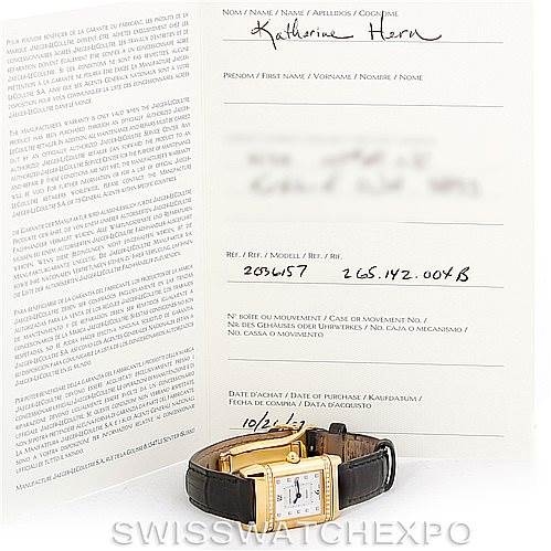 The image shows a Jaeger LeCoultre Reverso 265.1.08 Women's Yellow Gold Mother of Pearl Dial 265.1.08 Women's Yellow Gold Mother of Pearl Dial watch laid flat with its paperwork displayed behind it.