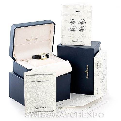 The image shows a Jaeger-LeCoultre Reverso watch in its open box, along with paperwork, manuals, and additional packaging.