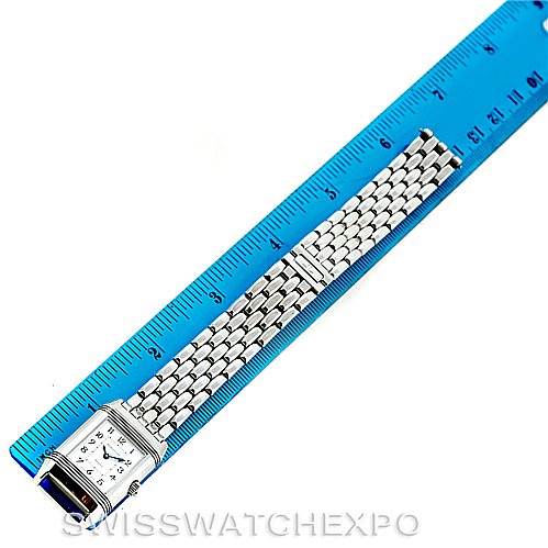 This image shows a Jaeger LeCoultre Reverso 266.8.44 Women's Stainless Steel Mother of Pearl Dial 266.8.44 Women's Stainless Steel Mother of Pearl Dial watch displayed with its rectangular face and metal bracelet stretched alongside a blue ruler.