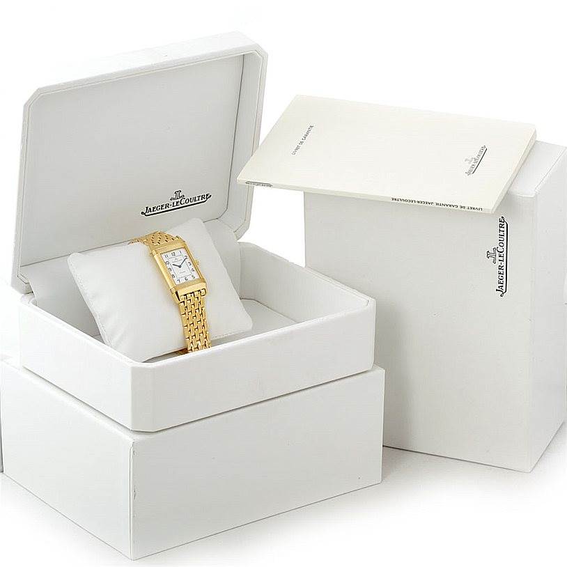 The image showcases a Jaeger LeCoultre Reverso 250.1.86 Men
s Yellow Gold Silver Dial 250.1.86 Men
s Yellow Gold Silver Dial watch resting in an open display box with associated packaging and documentation.