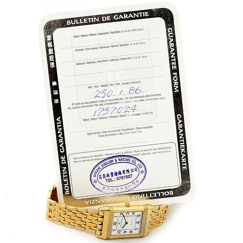 The image shows a Jaeger LeCoultre Reverso 250.1.86 Men
s Yellow Gold Silver Dial 250.1.86 Men
s Yellow Gold Silver Dial watch and its warranty form, angled slightly from above.