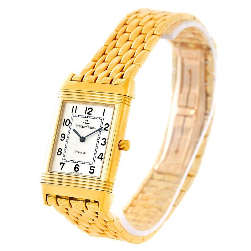 The image shows a front angle view of the Jaeger-LeCoultre Reverso watch, highlighting its rectangular face, gold case, and linked bracelet.