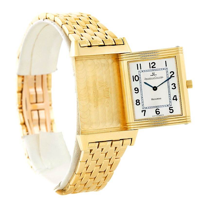 The Jaeger-LeCoultre Reverso watch is shown at an angle highlighting its face and reversible back on a gold bracelet.